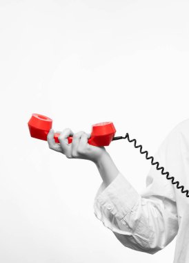 Beyaz tişörtlü, kıvırcık saçlı, eski bir telefondan konuşan güzel sarışın kız.