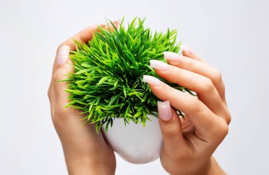 Güzel soluk pembe manikürlü bir kızın elleri. Güzellik salonundaki tırnak uzatma prosedürü. Profesyonel el bakımı..