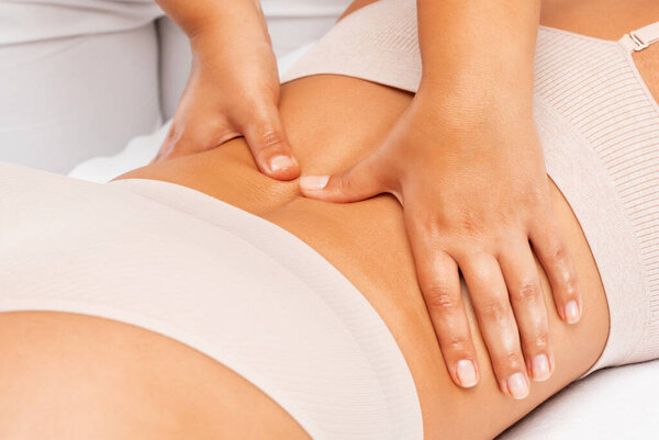 Masseur makes anti-cellulite massageon the legs, thighs, hips and buttocks in the spa. Overweight treatment, body sculpting.Cosmetology and massage concept.