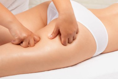 Masör bacaklara, kalçalara, kalçalara ve kalçalara antiselülit masajı yapıyor. Aşırı kilolu tedavi, vücut heykeli. Kozmetik ve masaj konsepti..