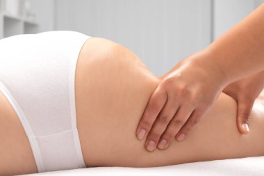 Masör bacaklara, kalçalara, kalçalara ve kalçalara antiselülit masajı yapıyor. Aşırı kilolu tedavi, vücut heykeli. Kozmetik ve masaj konsepti..