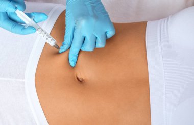 Bir kadının vücudunda yağ yakmak için lipotik enjeksiyon. Güzellik salonunda kadın estetiği. Kozmetoloji konsepti..