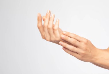 Yakından bakıldığında güzel bakımlı bir kadın elleri. Kız ellerinin derisine losyon sürüyor..