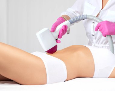 Bir kadının vücudunda tüy çıkarma prosedürü. Güzellik uzmanı bir güzellik salonunda lazer gençleştirme yapıyor. İstenmeyen vücut kılları alınıyor. Donanım ipl kozmetolojisi