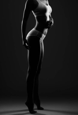 Beyaz bir kozmetoloji odasında beyaz iç çamaşırlı ince esmer bir kadın. Sağlıklı yaşam tarzı, spor ve diyet.