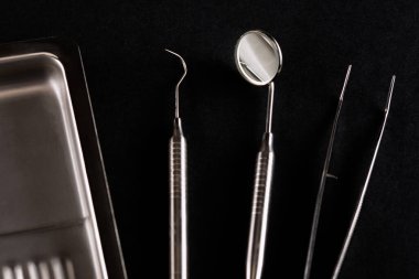 Siyah arka plandaki diş aletleri yakın plan. Hastanın muayenesi için dişçinin hazırlanması.