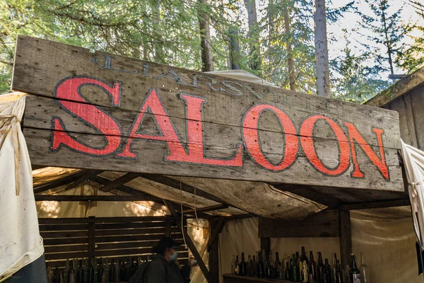 Old saloon sign above a tent in western gold mining camp