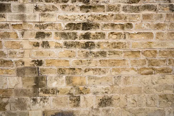 Weathered old rustic limestone exterior stone wall background