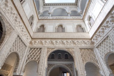 Sevilla, İspanya - 1 Eylül 2023: Sevilla İslami Maskesi 'nin Kraliyet Alcazar' ında süslü mermer kemerli sütunlar ve avlu