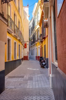 Seville İspanya 'nın tarihi şehir merkezinde motosikletli dar bir sokak.