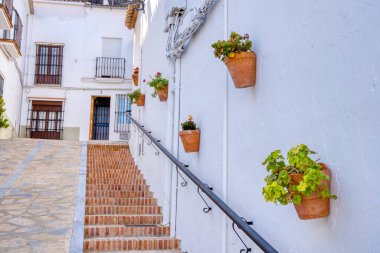 İspanya 'nın Endülüs bölgesinde Cadiz iline bağlı Zahara de la Sierra beyaz köyünde, sokak boyunca asılı çiçek saksıları