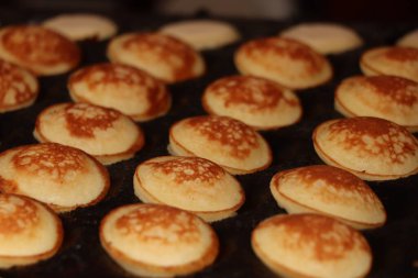 Sıcak döküm plaka, toz şeker ve tereyağı ile servis yapılan Poffertjes, Hollandalı küçük, tüylü krep,.
