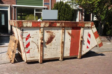 İnşaat alanının yakınındaki dolu çöp konteynırları, tadilat ya da bakım.