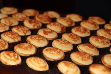 Sıcak döküm plaka, toz şeker ve tereyağı ile servis yapılan Poffertjes, Hollandalı küçük, tüylü krep,.