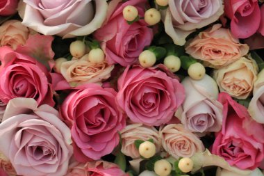 Büyük bir düğün süsü içinde pembe ve mor güller.