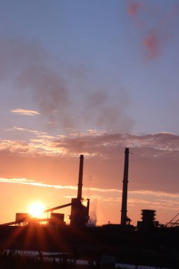 Gün batımında sanayi bölgesinin silüeti