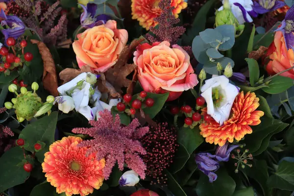 stock image Autumn wedding flower arrangement: roses and gerberas in a warm orange shade with purple and dark red.