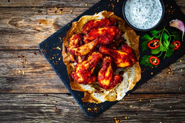 Buffalo wings with ranch dressing on wooden table