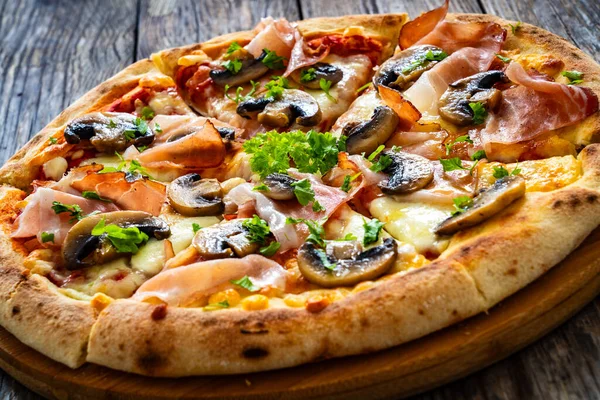 在木制桌子上放有火腿 莫扎拉奶酪和白蘑菇的比萨斑点 — 图库照片