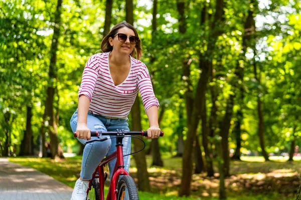 市立公園で自転車に乗っている美しい中年の女性 — ストック写真