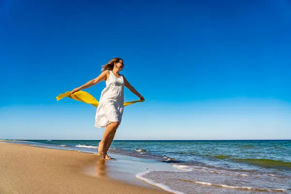 stock image Beautiful mid adult woman walking, running on sunny beach 