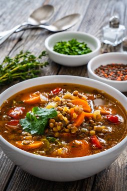 Fresh vegetable soup with lentil on wooden table  clipart