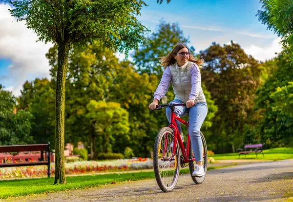シティパークで自転車に乗る中年女性 — ストック写真