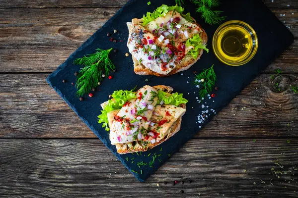 Tasty Sandwiches Toasted Bread Pickled Herrings Red Onion Wooden Table — Stock Photo, Image