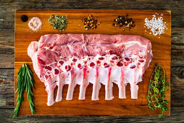 木桌上切板上的生牛肉排骨 — 图库照片