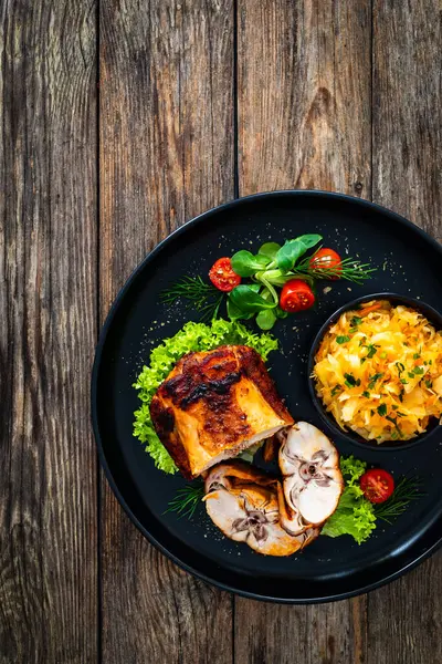 木のテーブルにベイクウサギのサドルと野菜サラダ — ストック写真