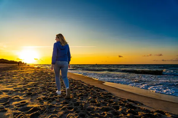 美しい中間の大人の女性は日没でビーチを歩く — ストック写真