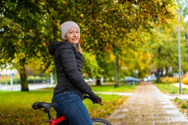 Donna Mezza Età Bicicletta Nel Parco Cittadino Una Giornata Piovosa Immagine Stock