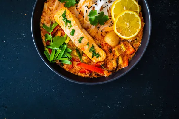 Tom Yum Thai汤 配上鲑鱼和米粉 放在木制桌子上 图库图片