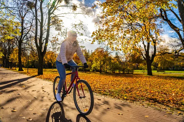Mid Adult Woman Riding Bicycle City Park Autumnal Scenery Stok Lukisan  