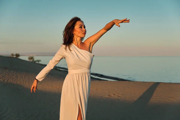 Dziewczyna Białej Sukience Tańczy Pozuje Pustyni Zachodzie Słońca — Zdjęcie stockowe