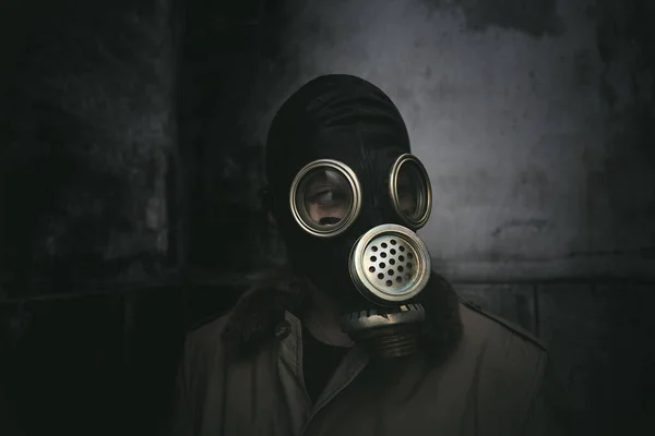 老朽化した建物の暗闇の中にガスマスクを身に着けている男本の表紙 — ストック写真
