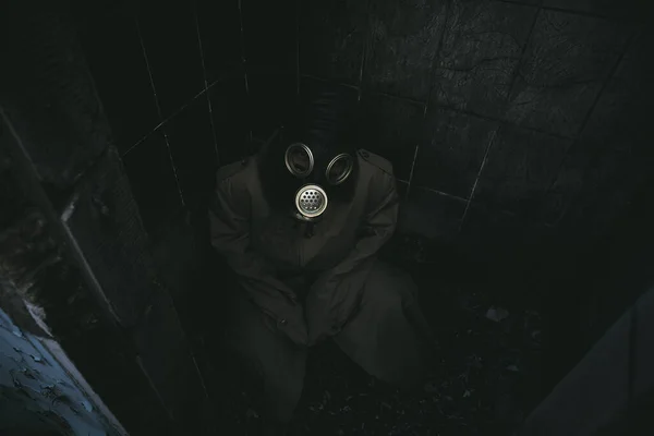 Een Man Met Een Gasmasker Zit Een Kleine Donkere Kamer — Stockfoto