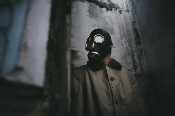 古い建物の中に立っているガスマスクの男は 隅の周りを見て 本のカバーのために良い — ストック写真
