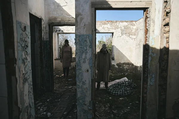 ガスマスクの男と破壊された建物の女性は 別の部屋に立って 本のカバーのために良い — ストック写真