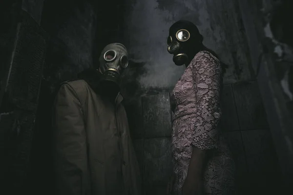 Two People Gas Masks Stand Wall Small Dark Room Low — Stock Photo, Image