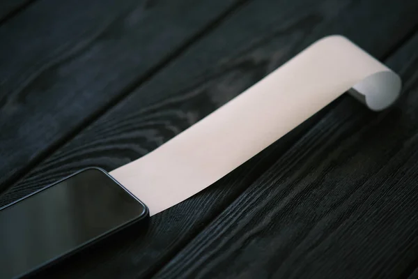 Téléphone Portable Avec Chèque Blanc Sur Une Table Bois Noir — Photo