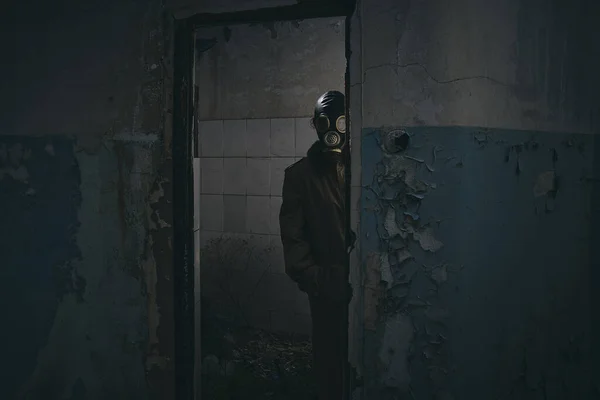 Ένας Άνθρωπος Μάσκα Αερίου Στέκεται Μέσα Ένα Παλιό Κτίριο Κρυφοκοιτάζοντας — Φωτογραφία Αρχείου