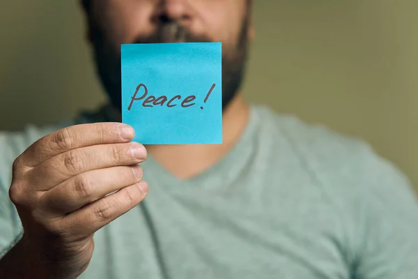 Bearded European Man Holds Blue Sticker Front Him Word Peace Stock Photo