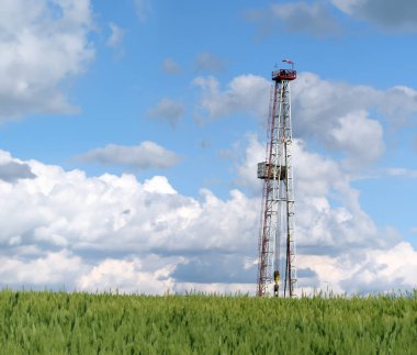 Petrol sondaj kulesi ve bulutlu mavi gökyüzü