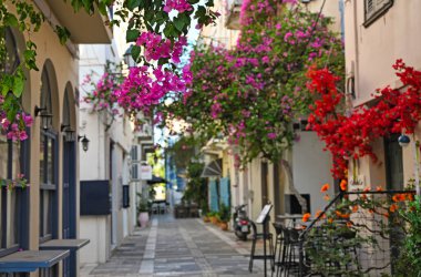 Nafplion şehrinin dar sokaklarında Bougainvillea çiçekleriyle dolu restoran ve binalar.