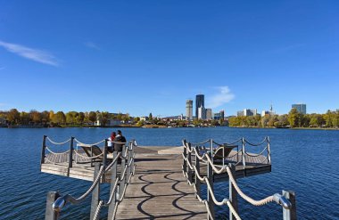 People enjoy a sunny autumn day on the Danube river in Vienna clipart