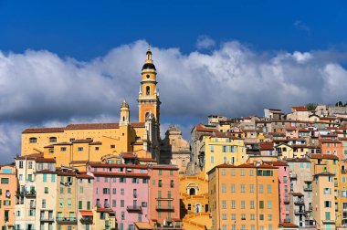 Colorful old buildings and church tower in Menton city, France, summer season