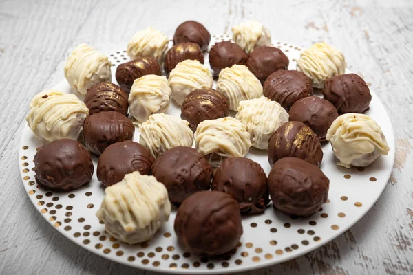 Chocolate truffles on plate on white table. Homemade. Praline bonbons.