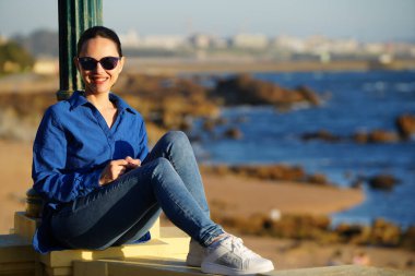 Gün batımında gezinen kadın, Pergola Foz, Portekiz 'de denizin yanında.