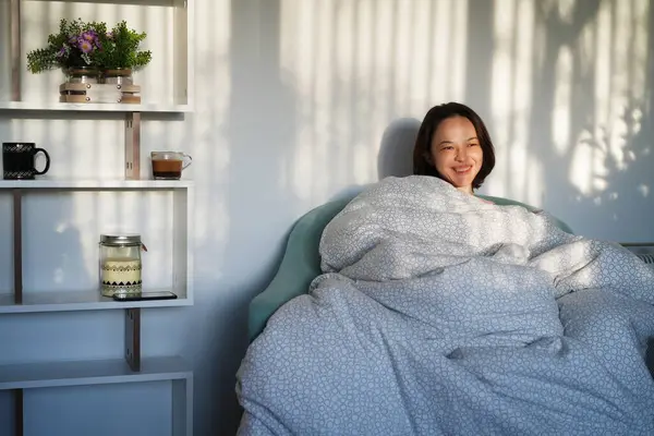 Oturma odasındaki kanepede uyandıktan sonra rahat, dingin bir yetişkin kadın.